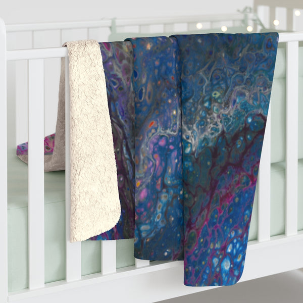 Blue galaxy sherpa fleece blanket on baby crib