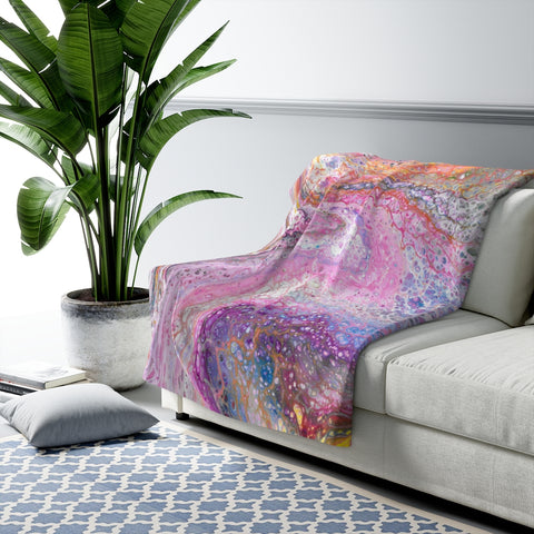 Pink galaxy art sherpa fleece blanket on couch