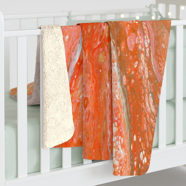 Orange abstract sherpa fleece blanket on baby crib