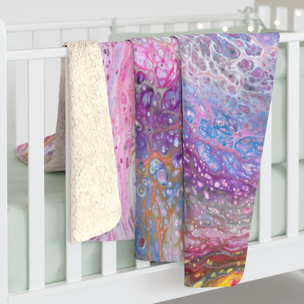 Pink galaxy art sherpa fleece blanket on baby crib