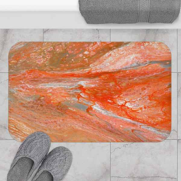 Orange abstract art bath mat on gray bathroom floor